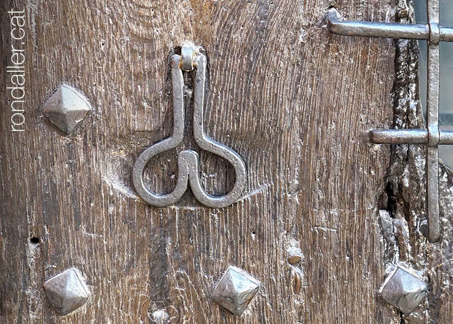 Trucador amb forma de genitals masculins a la porta de la capella de Sant Vicent.
